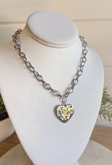 Simple, stylish, and oh-so versatile—this silver chain necklace is the perfect finishing touch for any look. Designed with a textured heart charm, it adds just the right amount of detail and personality without overpowering your outfit. With its adjustable extender, you can wear it closer to the neckline for layering or a little longer on its own. A timeless piece you’ll keep reaching for, no matter the occasion.