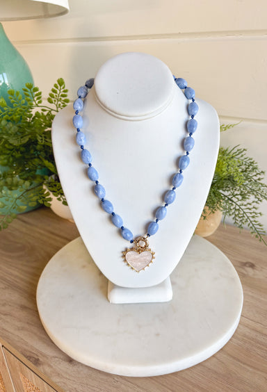 Add a touch of sweetness to your style with this light blue beaded necklace featuring a white heart charm outlined in gold. Delicate yet eye-catching, it’s the perfect piece to wear year-round. The 20" length with a 3" extender makes it easy to layer or wear solo for a simple, charming finish.