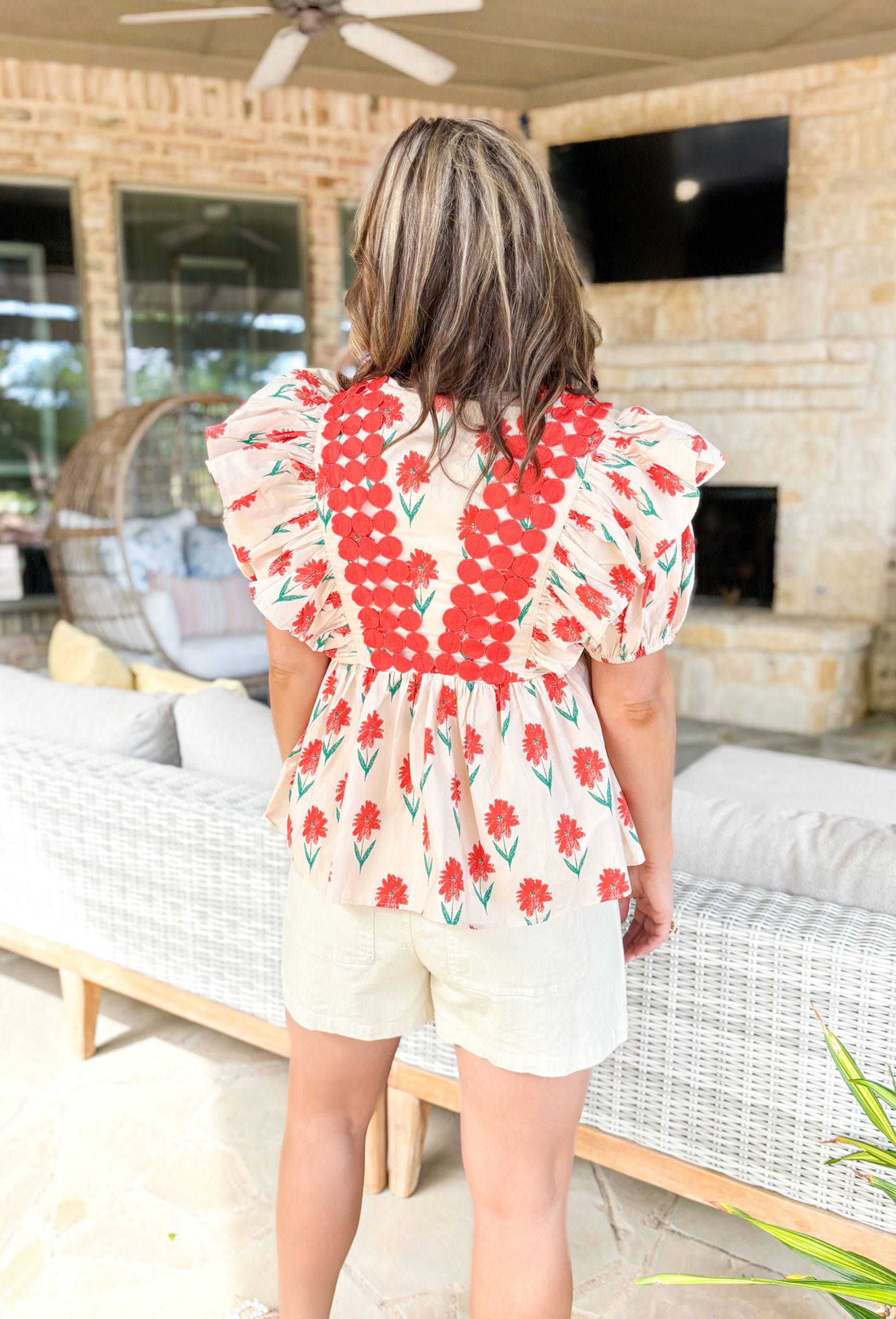 Happy Blooms Floral Blouse, puff/ruffle sleeve blouse with red and green floral print. Red circle overlay across the chest and over the shoulders