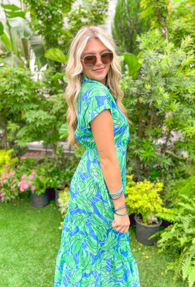 Tropical Oasis Midi Dress, blue dress with green leaf detail, buttons down the chest and collar, tiering down the whole dress 