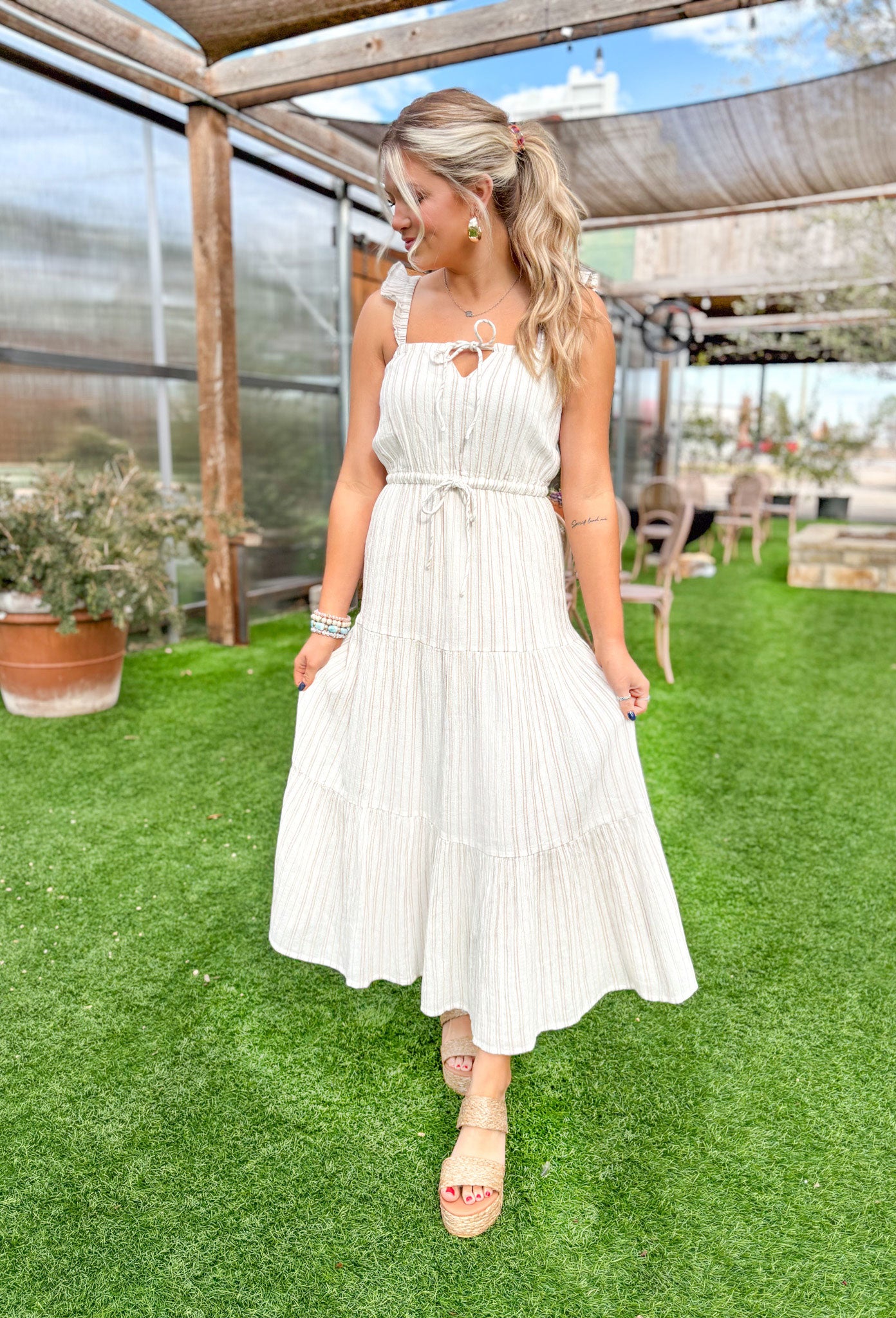 Z SUPPLY La Brisa Dobby Stripe Dress, cream/ bone dress with taupe vertical stripes, ruffle detailing on the spaghetti straps, a small opening with tie detail on the chest, and cinching on the waist line with a drawstring 