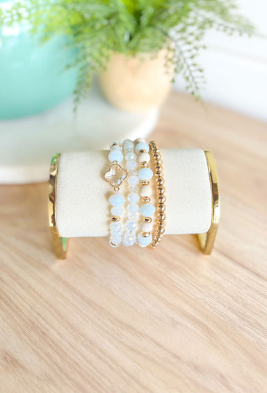 More Drama Bracelet Set in White, stack of 4 beaded bracelet, 3 bracelets are white clear and gold mix, one bracelet is all gold beads