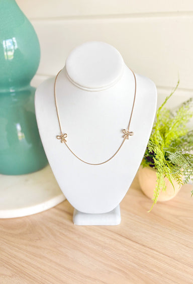 The Only Way Necklace, dainty gold chain necklace with two gold bows on either side of the middle of the chain 