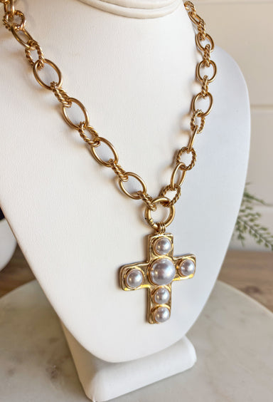 This chunky gold chain necklace makes a bold yet timeless statement. Featuring a gold cross adorned with pearls, it blends modern edge with classic elegance. The toggle clasp closure adds a stylish touch while keeping it easy to wear. Perfect for elevating casual looks or adding a refined accent to dressier outfits.