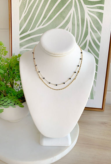 In A Daydream Necklace, dainty layered gold necklace with one thin chainlink layer and one black beaded layer
