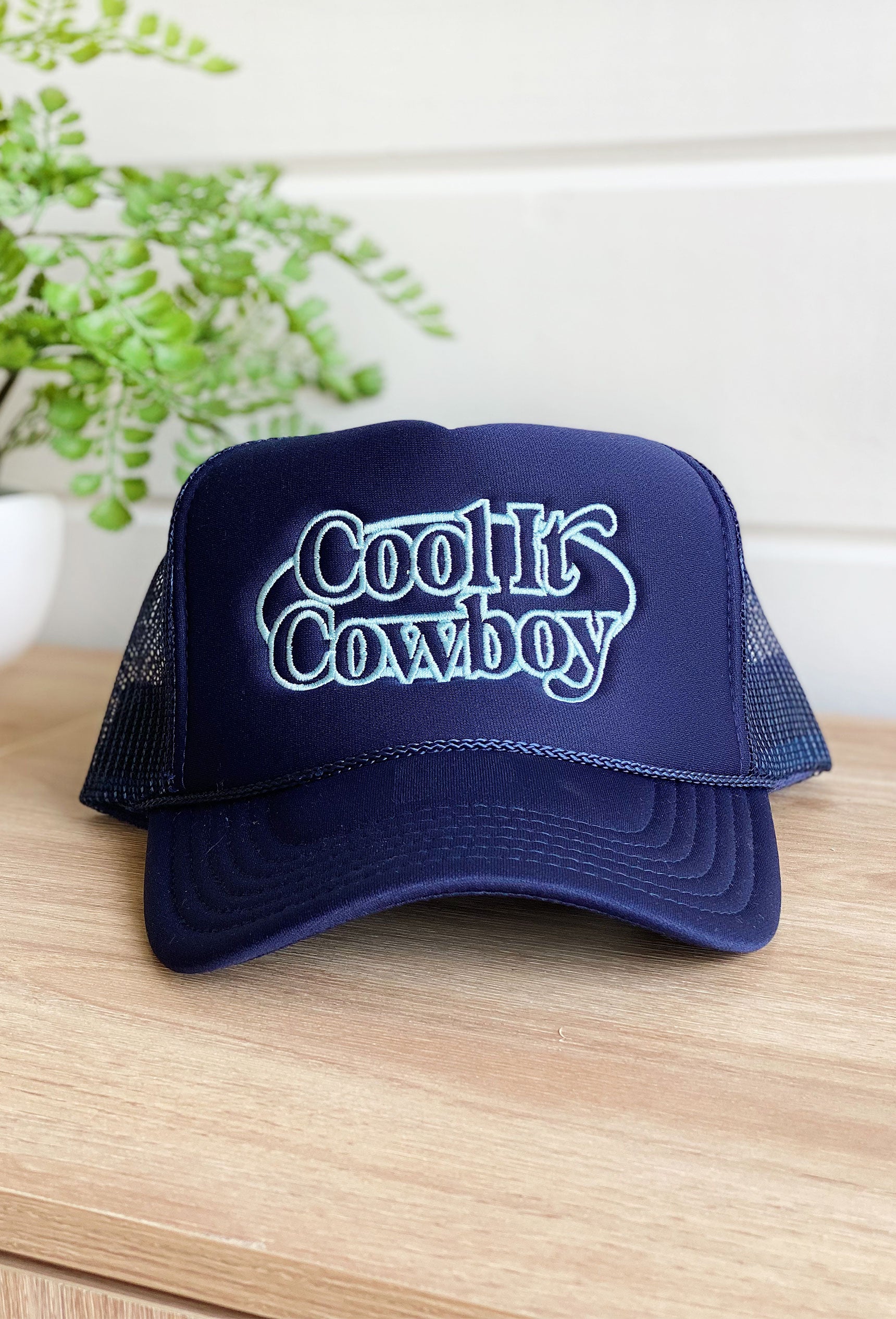 Charlie Southern: Blue Cool It Cowboy Trucker Hat, navy trucker hat with lettering embroidered in light blue that says "cool it cowboy"