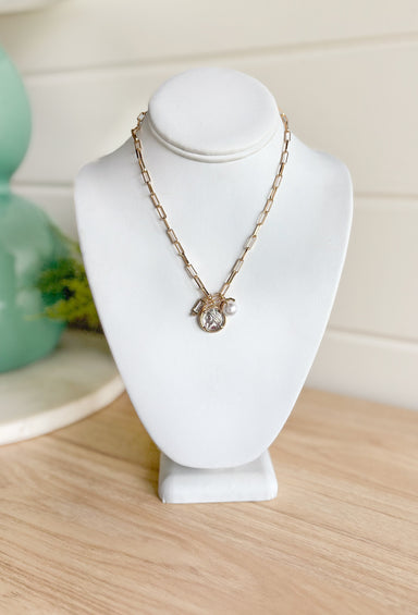 First Glances Necklace in Gold, gold paper clip chain necklace with rhinestone, coin, and pearl charm in the center
