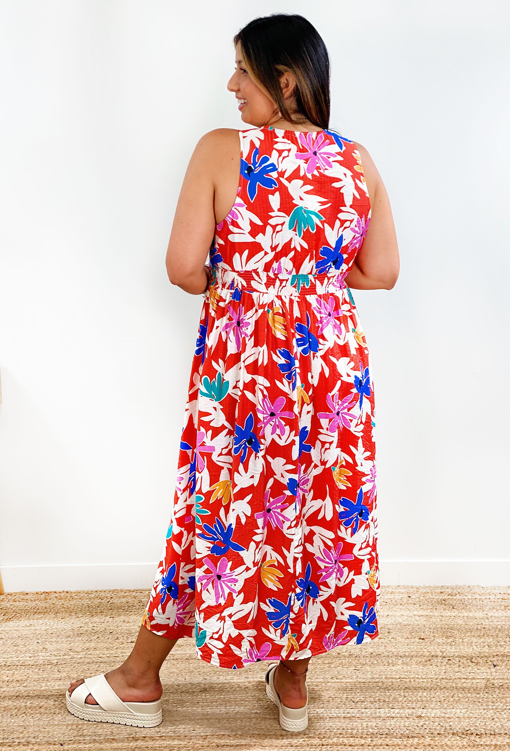 Island bloom midi dress. Red dress featuring a floral print with pops of color and a v-neck line.