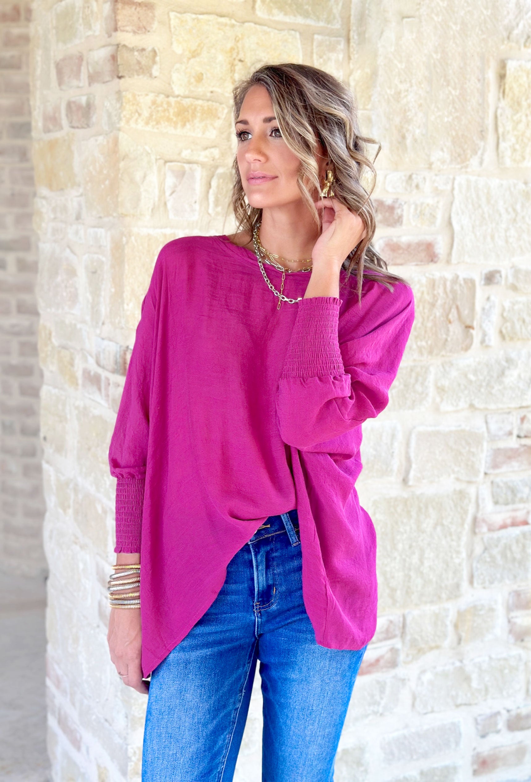 Long Time Gone Top, fuchsia long sleeve blouse with cinching on the wrists and asymmetrical hemline 