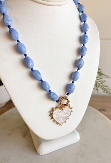 Add a touch of sweetness to your style with this light blue beaded necklace featuring a white heart charm outlined in gold. Delicate yet eye-catching, it’s the perfect piece to wear year-round. The 20" length with a 3" extender makes it easy to layer or wear solo for a simple, charming finish.