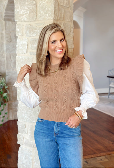 Manhattan Chill Top, ruffle sweater vest in tan over a white longsleeve blouse with cinched wrists that have ruffles on the hem