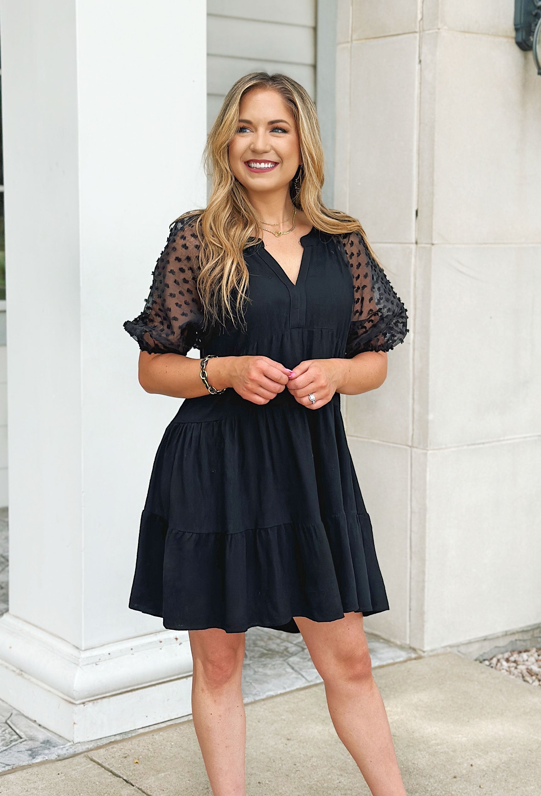 Meet Me In Paris Dress, Black tiered puff sleeve v-neck dress. Sleeves are sheer with textured puffs 