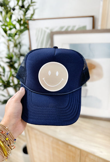 Naturally Happy Trucker Hat in Navy, navy trucker hat, navy mesh backing, adjustable, tan smiley face patch on front of hat