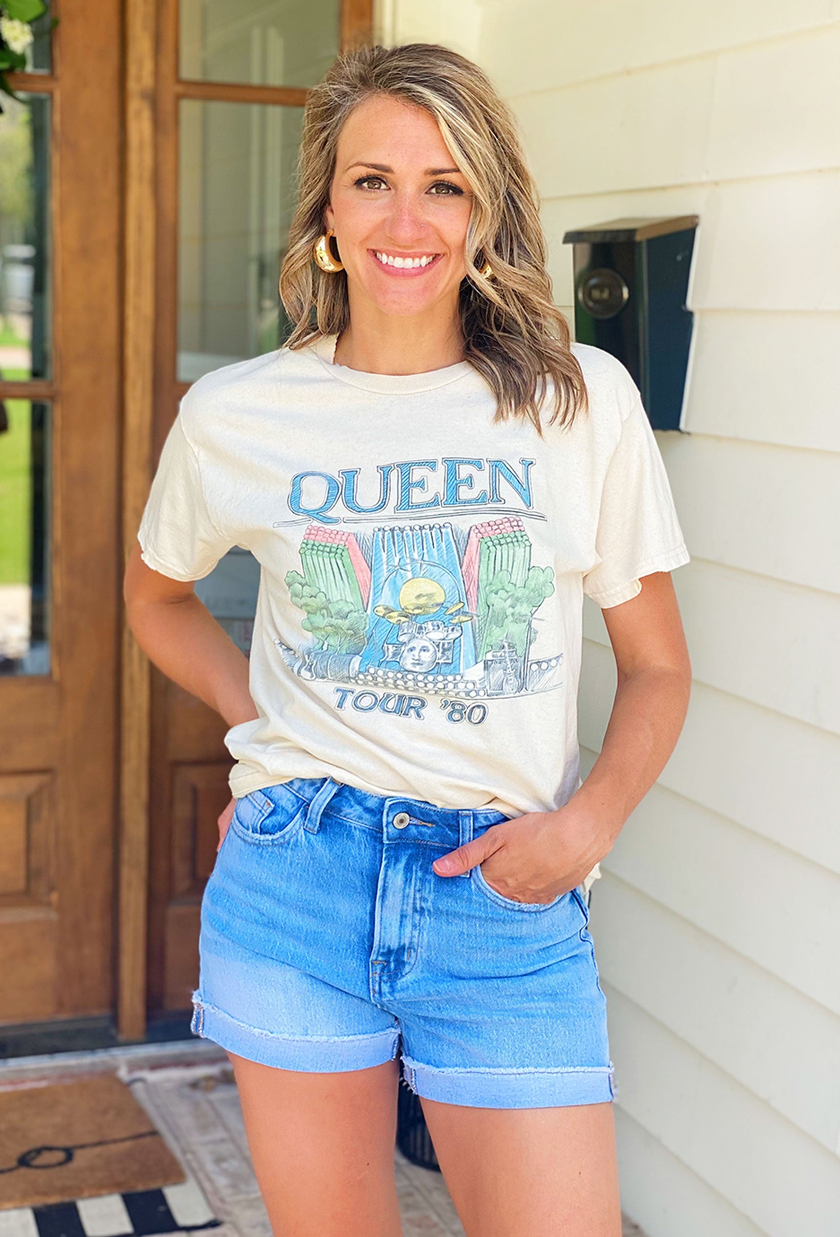 Queen Graphic Tee, neutral tee features the iconic "Queen Tour '80" logo and an on stage graphic