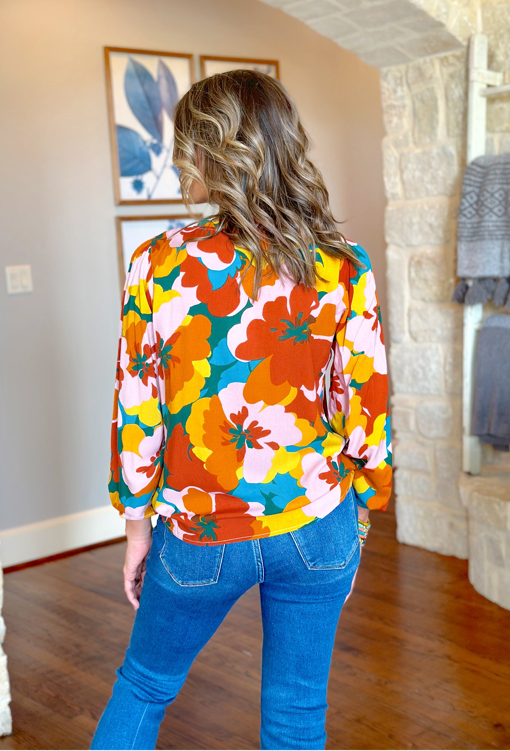 Seasons Change Floral Blouse, red, orange, yellow, teal, turquoise and light pink floral long sleeve blouse. blouse has ruffles on the wrists and neckline, soft v-neck, and strings 