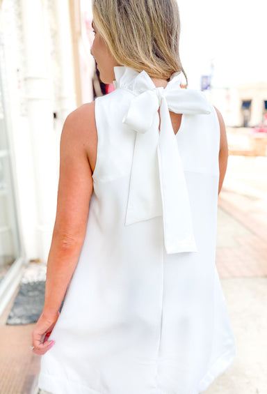 Capri Calling Dress in Off White, white sleeveless high neck dress, ruffling around the neck, bow detail on the back of the neck that drapes down the back