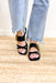 Flaxen Sandals in Black, flat sole faux leather strapped sandals with two small straps over the toes and one big strap over the top of the foot with a gold bamboo buckle