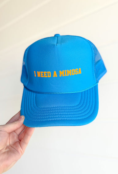 I Need A Mimosa Trucker Hat, vibrant blue trucker hat with bright orange font "I need a mimosa" on the front