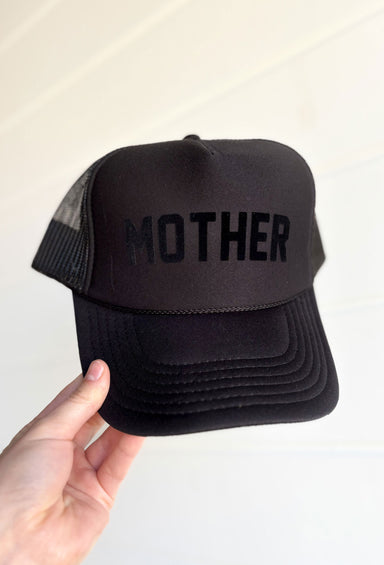 Mother Trucker Hat, solid black hat with black velvet font "mother" on the front. monochrome