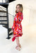 Always Stand Out Dress, red, pink, orange, burgundy, and white abstract line dress with long sleeves, high neck, and tie detail on the back of the neck