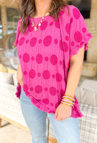 By All Means Top, short sleeve hot pink top with fraying on the sleeve and waist hem. peekaboo spot details across the whole blouse