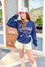 Charlie Southern: Texas Bow Sweatshirt, navy crewneck with light pink graphic saying "texas" with a rope bow underneath 
