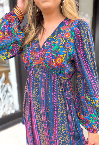 Date Night In Florence Midi Dress, long sleeve midi dress with v-neck. Navy base with red, pink, fuchsia, yellow, green, orange, light blue, and cobalt boho floral pattern