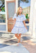 Feeling Blue Floral Dress, short puff sleeve baby doll dress with blue and white floral printing, rick rack on the chest, waist, and half way to the bottom of the dress in a denim blue, dress is button up and has a collar