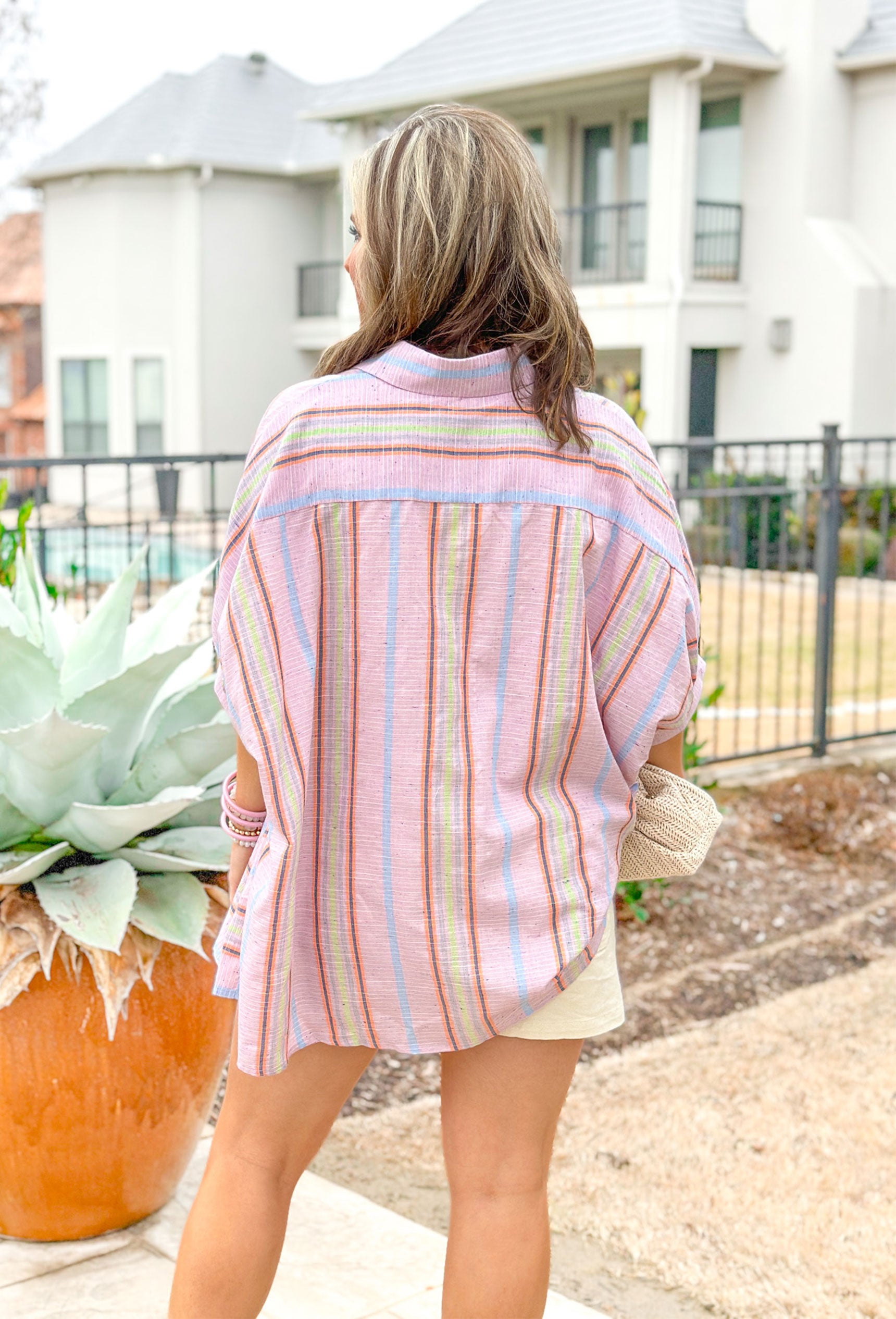 First Things First Top in Rose Pink, light purple-ish/pink blouse with sage, orange, grey, blue and white stripes going horizontal on one side and vertical on the other side