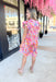 Flower Bomb Dress, paisley floral print short sleeve dress. Ruffle detailing on the sleeves and neckline, in the colors pink, periwinkle, yellow, orange, red, green, and cream 
