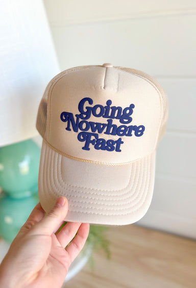 Going Nowhere Fast Trucker Hat in Tan, solid tan trucker hat with navy font "going nowhere fast" on the front