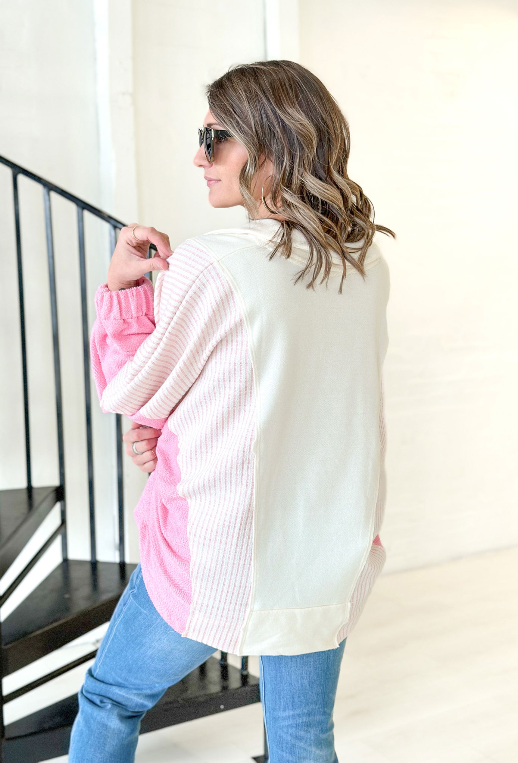 Make It Right Pullover, oversized pullover with collar and slight v-neck. chest is white, shoulder and sides are white and pink striped and the bottom of the sleeves are pink 