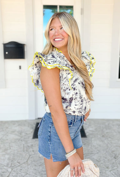 Might Surprise You Top, black and white palm leaf print top with neon yellow trimming on the ruffle sleeves and around the neck, v-neck line
