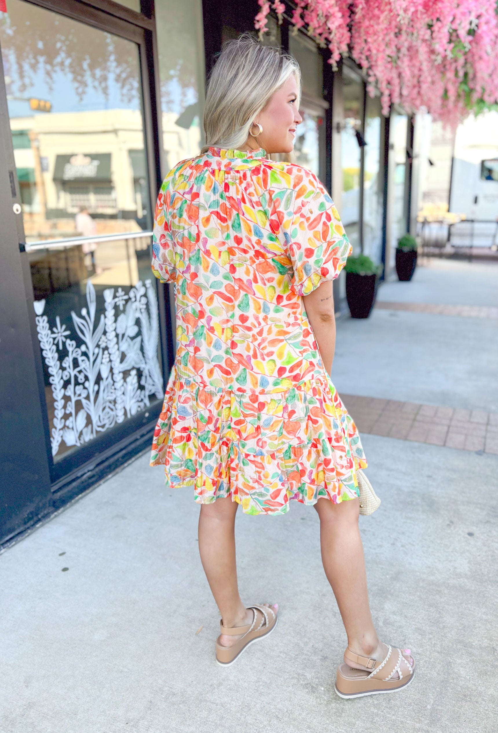 Paradise Awaits Dress, short puff sleeve dress with soft v-neck, ruffling around the neck, string details on the neck, abstract print in the colors cream, orange, yellow, red, and green
