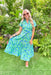 Tropical Oasis Midi Dress, blue dress with green leaf detail, buttons down the chest and collar, tiering down the whole dress 