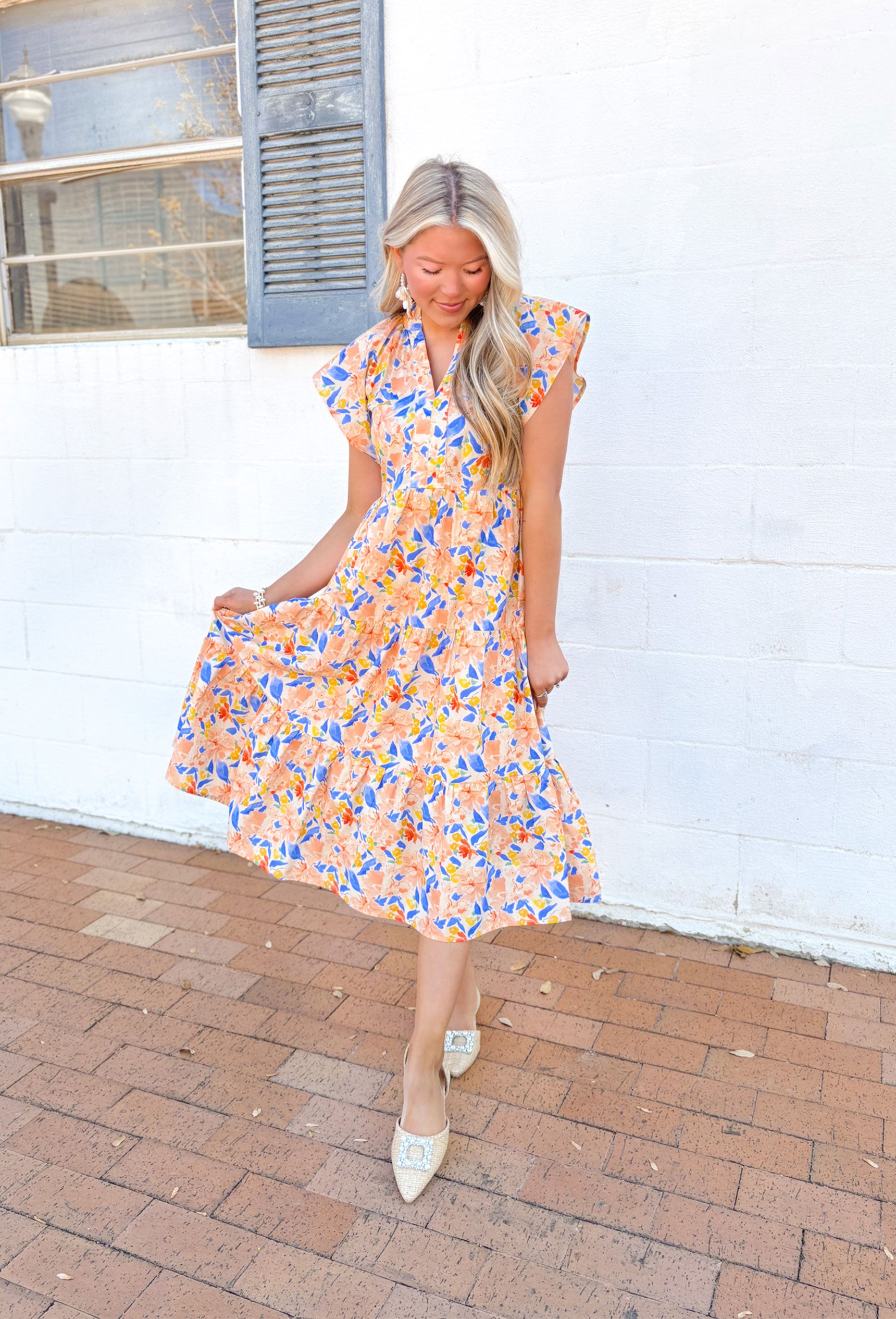 Wishing For Florals Midi Dress, ruffle sleeve v-neck tiered midi dress with orange, blue, yellow, and tomato red floral pattern, ruffling around the neck, and pockets 