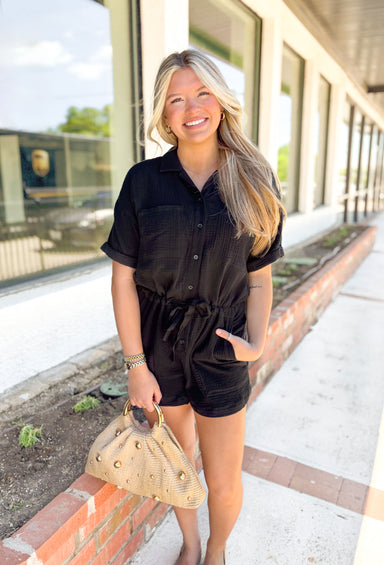 Z SUPPLY Lookout Gauze Romper, black gauze short sleeve button down romper with drawstring around the waist, rolled sleeves, front pockets on the chest and pockets at the waist