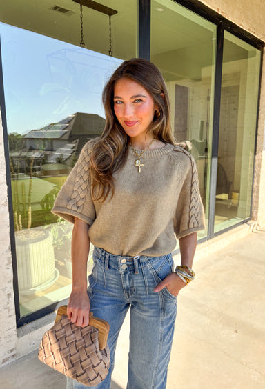 Cozy meets casual in this oatmeal sweater top, perfect for those in-between fall days. Designed with short raglan sleeves and a braided sleeve detail, it brings just the right amount of texture to your outfit. The ribbed hem, cuffs, and neckline give it a classic sweater finish, while the soft knit blend makes it comfortable for all-day wear. Easy to pair with jeans, skirts, or layered under a jacket, this is a versatile staple you’ll reach for again and again.