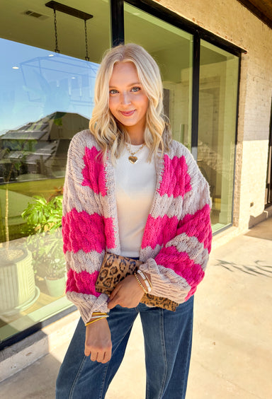 This tan and hot pink striped cardigan is the perfect blend of bold and cozy! The chunky knit design adds just the right amount of texture, while the vibrant pink stripes give it that playful pop your fall wardrobe’s been craving. It’s the ideal throw-on-and-go layer for everything from chilly mornings to pumpkin patch strolls.