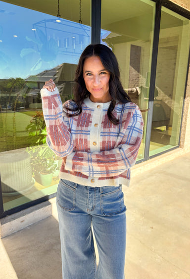 Plaid meets cozy charm in this cropped button-down cardigan. Designed in cream, blue, dark pink, and light pink, it’s the perfect pop of color for cooler days. Gold textured buttons add a polished detail, while the soft knit blend makes it extra comfortable. With its cropped fit and long sleeves, this cardigan is easy to style layered over a cami, tee, or even a dress for that just-right fall look.