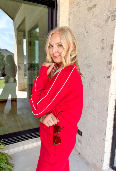 Sporty meets cozy in this red pullover. White stripe details run down the sleeves for a casual, athletic-inspired touch, while the soft modal-blend fabric keeps it comfortable and easy to wear all day long. With its relaxed fit and cozy feel, this piece is perfect for layering or wearing solo on cool fall days.&nbsp;