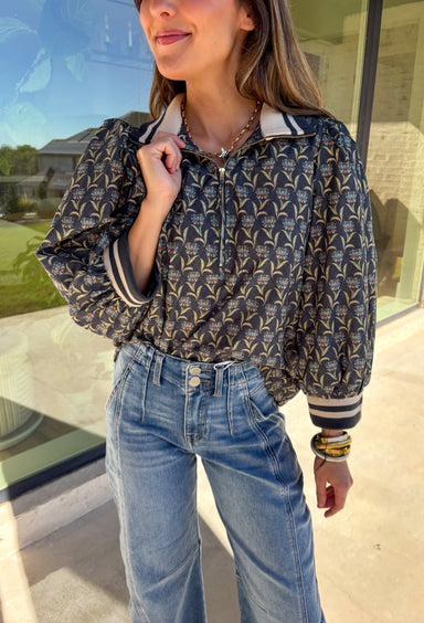 This midnight floral top by Entro is the perfect blend of casual comfort and standout style. Featuring ¾ puff sleeves and a sporty contrast ribbed stand collar and cuffs, it adds a playful edge to the feminine floral print. Shades of green and blue give it a cool, seasonal vibe, while the half zip front closure adds a touch of versatility. Made from 100% cotton, it’s lightweight, breathable, and perfect for transitional weather.