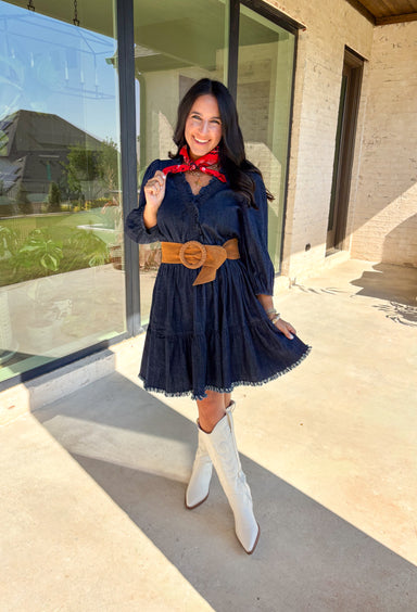 Denim with a feminine twist—this long sleeve dress is a seasonal must-have. Designed in a rich dark wash, it features a flattering smocked waist and a raw edge hem that adds a casual, lived-in feel. The ruffle trim softens the look, while elastic cuff sleeves keep it comfortable and easy to wear. Made from a cotton blend, it’s lightweight enough to layer and cozy enough to wear on its own for crisp fall days.