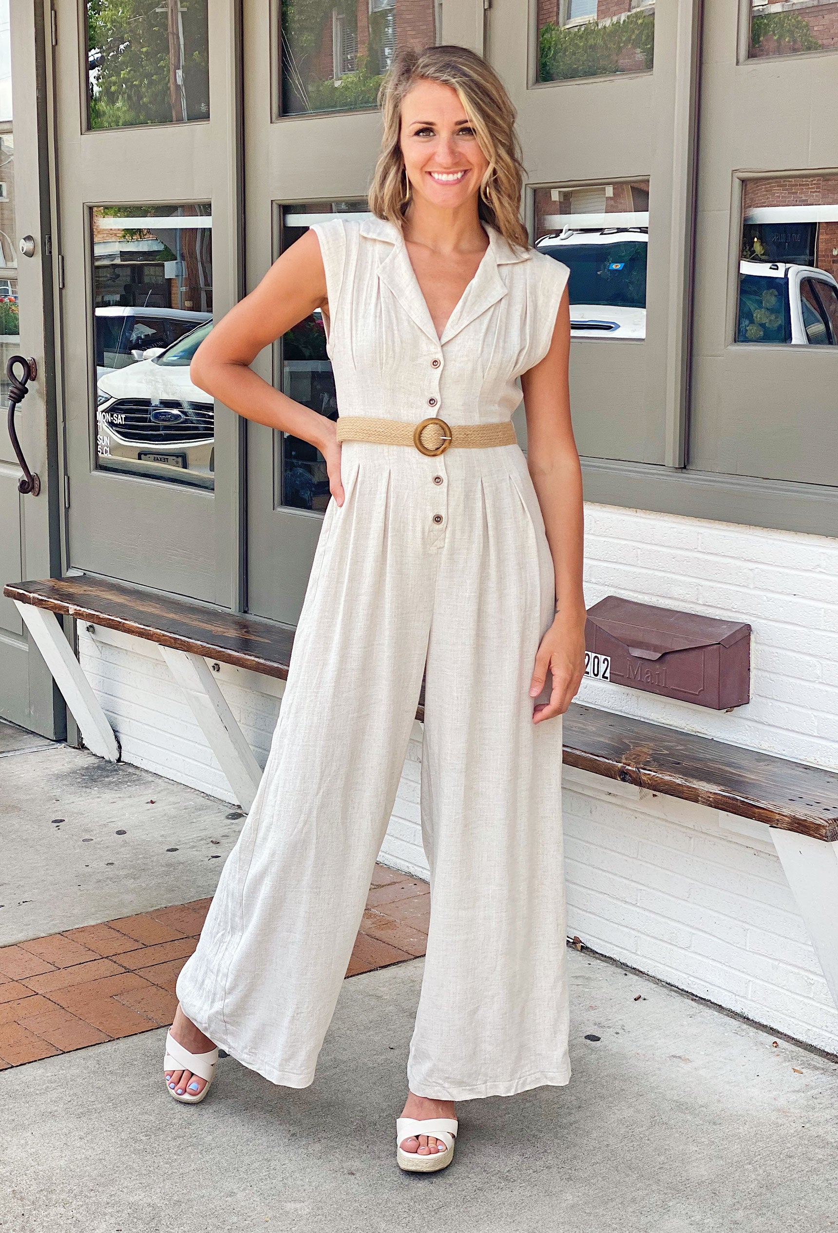 Where It Ends Linen Jumpsuit, Jumpsuit Featuring a neutral hue, wide leg, and button-up detail, this jumpsuit is elevated with a unique raffia and wooden belt detail