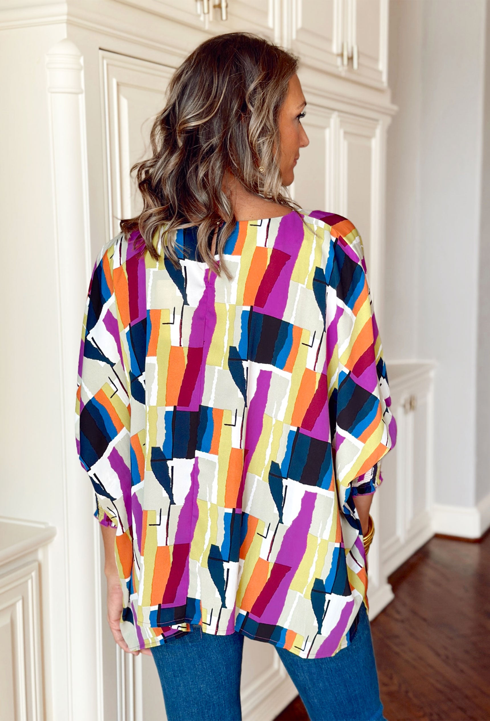 All Over Again Blouse, purple, blue, black, orange, lime, white, and taupe abstract shape top with cinched wrists 