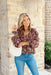 Autumn Charm Floral Blouse, cool brown long sleeve blouse with cinched wrists that have a ruffle detailing on the ends. V-neck line with taupe and tan floral designs all over the blouse