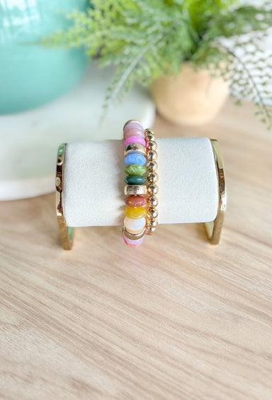 Better Than Ever Bracelet Set, stack of two bracelets, one is multicolored wide beads with gold in between every three beads, the other is a smooth gold beaded bracelet