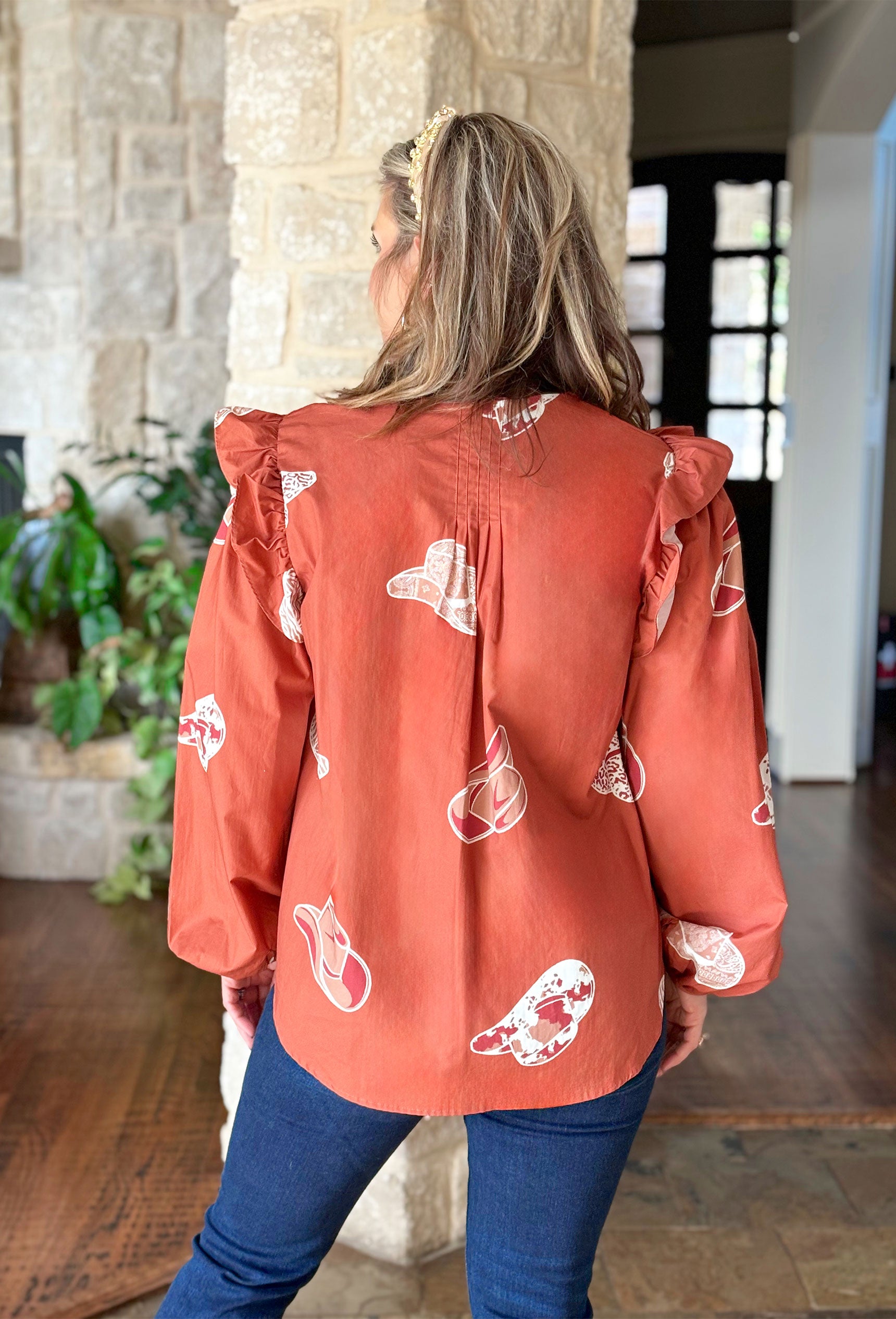 Cowboy Take Me Away Blouse, burnt orange blouse with ruffling across the chest and graphic cowboy hats all over the blouse