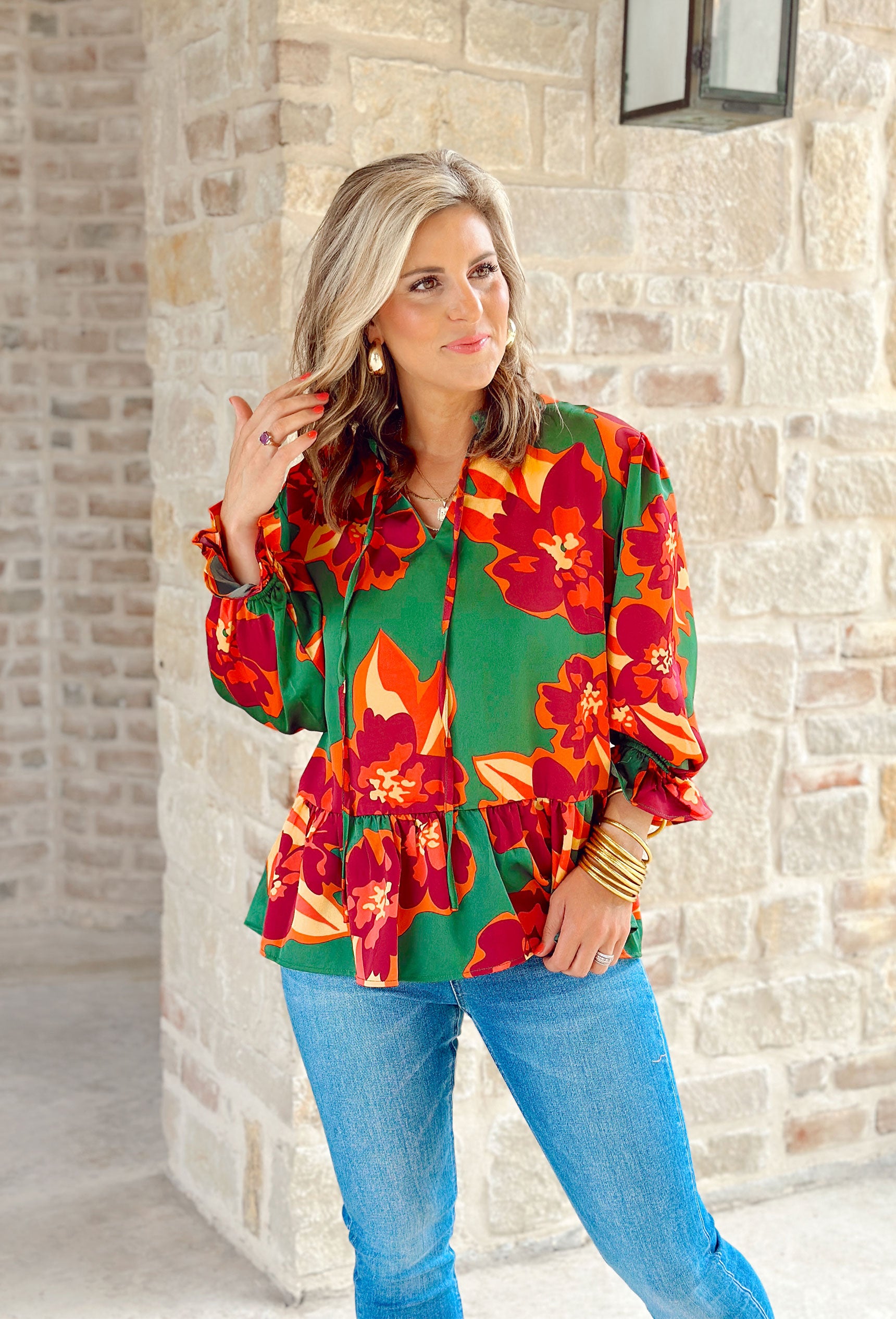 Lasting Love Floral Blouse, green long sleeve blouse with red, orange, and yellow flowers. Ruffling on the wrists and on the waist line