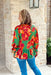 Lasting Love Floral Blouse, green long sleeve blouse with red, orange, and yellow flowers. Ruffling on the wrists and on the waist line